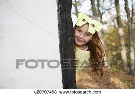 Stock Photo - Girl wearing butterfly mask outdoors. Fotosearch