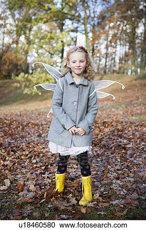 Stock Image - Girl wearing fairy wings in park. Fotosearch