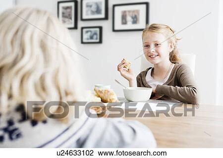 Girls eating lunch at table together View Large Photo Image Stock Image - Girls eating lunch at table together. Fotosearch