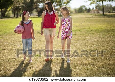 Girls walking together in field View Large Photo Image Stock Image - Girls walking together in field. Fotosearch
