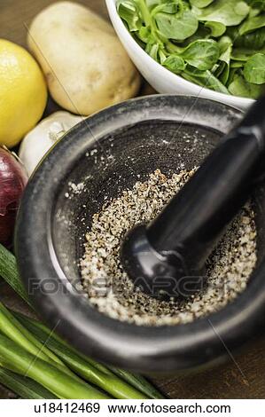 Stock Photo - Herbs crushed in pestle and mortar. Fotosearch