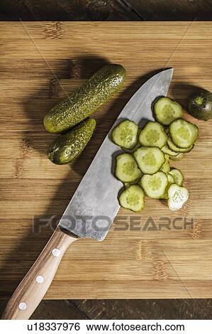 Stock Photograph - Knife with chopped pickles on table. Fotosearch