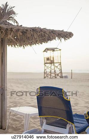 Lawn chair and umbrella on beach View Large Photo Image Stock Photograph - Lawn chair and umbrella on beach. Fotosearch