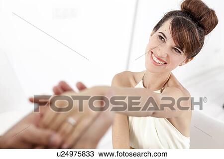 Stock Image - Man admiring fiances engagement ring. Fotosearch