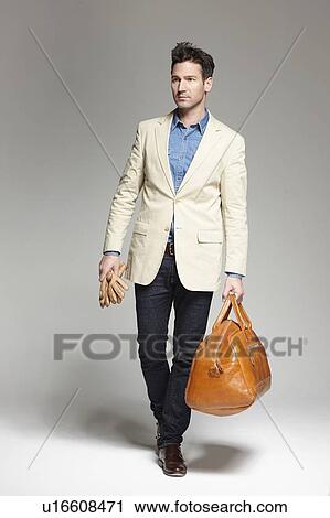 Stock Image - Man carrying gloves and luggage. Fotosearch