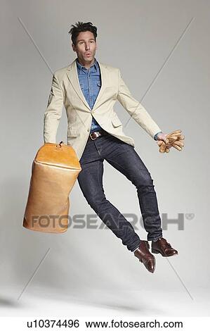 Stock Photograph - Man clicking his heels in mid air. Fotosearch