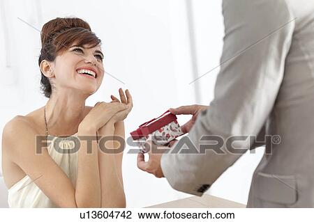Man giving smiling girlfriend present View Large Photo Image Stock Image - Man giving smiling girlfriend present. Fotosearch