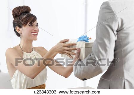 Stock Image - Man giving smiling girlfriend present. Fotosearch