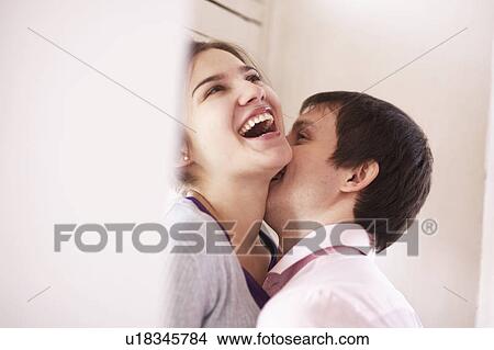 Man kissing girlfriend indoors View Large Photo Image Picture - Man kissing girlfriend indoors. Fotosearch