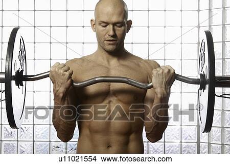 Man lifting weights in gym View Large Photo Image Picture - Man lifting weights in gym. Fotosearch