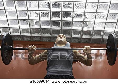 Man lifting weights in gym View Large Photo Image Picture - Man lifting weights in gym. Fotosearch