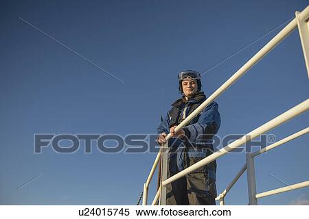 Stock Photography - Man standing on elevated walkway. Fotosearch