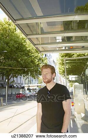 Stock Photo - Man waiting for city bus. Fotosearch