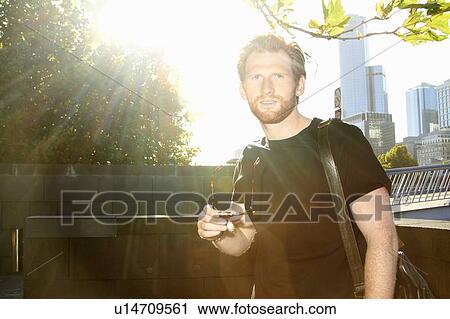 Stock Image - Man walking on city street. Fotosearch