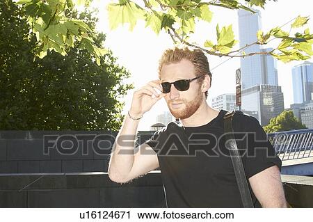 Man wearing sunglasses on city street View Large Photo Image Stock Image - Man wearing sunglasses on city street. Fotosearch
