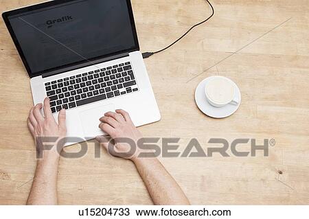 Stock Image - Mans hands, laptop and coffee cup. Fotosearch