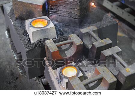 Stock Photo - Molten metal in moulds in foundry. Fotosearch