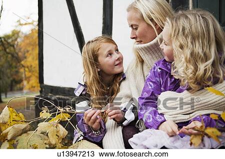 Mother and daughters sitting outdoors View Large Photo Image Stock Image - Mother and daughters sitting outdoors. Fotosearch