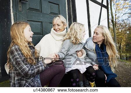 Stock Photo - Mother and daughters sitting outdoors. Fotosearch