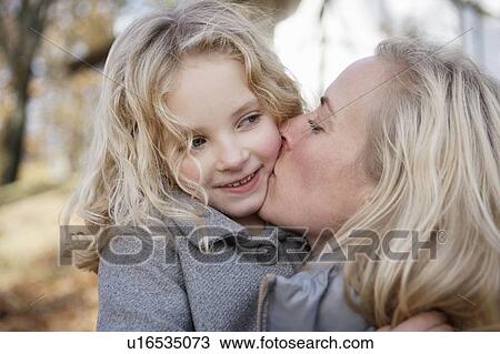 Mother kissing daughter outdoors View Large Photo Image Stock Image - Mother kissing daughter outdoors. Fotosearch