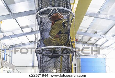 Picture - Oil worker training in escape net. Fotosearch