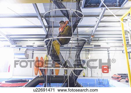 Stock Image - Oil worker training in escape net. Fotosearch