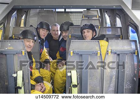 Stock Image - Oil workers in simulated helicopter. Fotosearch