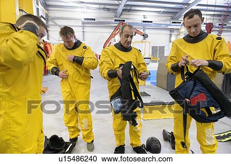 Stock Image - Oil workers removing protective gear. Fotosearch