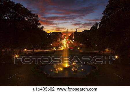 Stock Image - Ornate fountain with traffic at night. Fotosearch