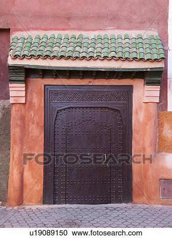 Stock Image - Ornate metal door on village street. Fotosearch