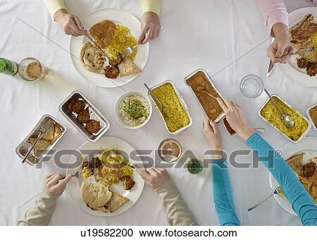 Stock Image - Overhead view of people at table. Fotosearch
