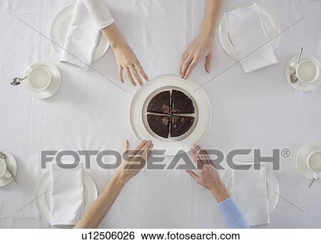 Stock Photograph - Overhead view of people sharing dessert. Fotosearch