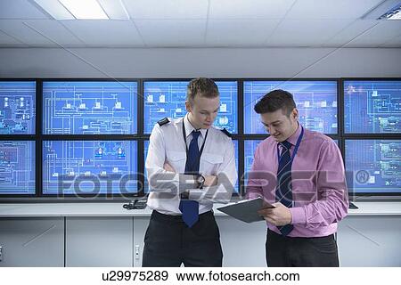 Stock Photo - Personnel working in ships engine room. Fotosearch