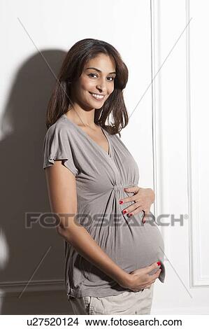 Picture - Pregnant woman holding her belly. Fotosearch