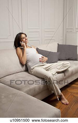 Stock Image - Pregnant woman talking on cell phone. Fotosearch