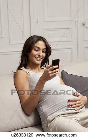 Pregnant woman using cell phone View Large Photo Image Stock Image - Pregnant woman using cell phone. Fotosearch