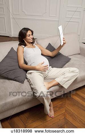 Pregnant woman using tablet computer View Large Photo Image Stock Photo - Pregnant woman using tablet computer. Fotosearch