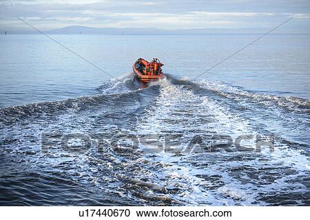 Stock Image - Rescue boat training in open water. Fotosearch