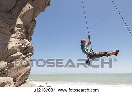 Rock climber abseiling jagged cliff View Large Photo Image Stock Photo - Rock climber abseiling jagged cliff. Fotosearch