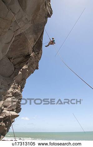 Rock climber abseiling jagged cliff View Large Photo Image Stock Photography - Rock climber abseiling jagged cliff. Fotosearch