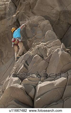 Rock climber scaling jagged cliff View Large Photo Image Stock Image - Rock climber scaling jagged cliff. Fotosearch