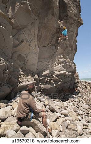 Stock Photo - Rock climber scaling jagged cliff. Fotosearch