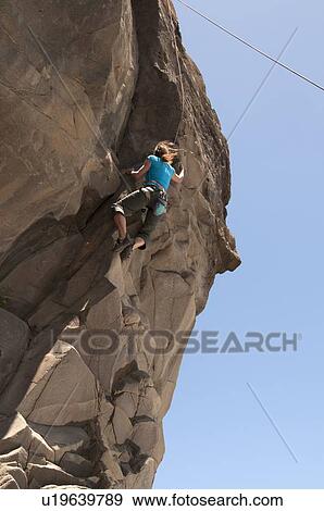 Rock climber scaling jagged cliff View Large Photo Image Stock Photo - Rock climber scaling jagged cliff. Fotosearch