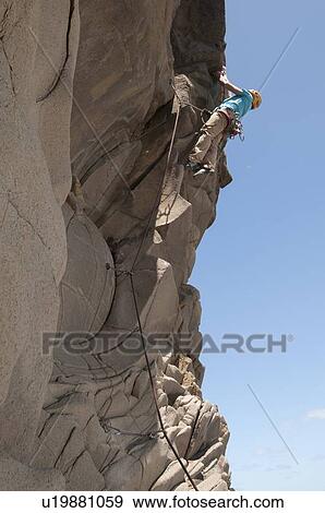 Rock climber scaling jagged cliff View Large Photo Image Stock Photo - Rock climber scaling jagged cliff. Fotosearch