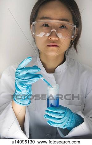 Scientist dropping liquid into beaker View Large Photo Image Stock Image - Scientist dropping liquid into beaker. Fotosearch