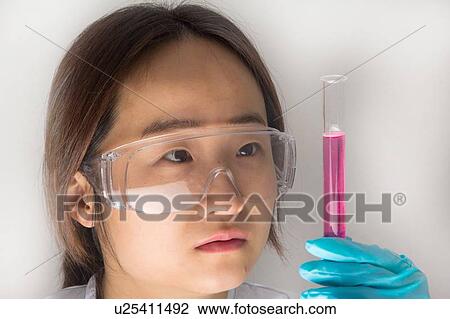 Stock Image - Scientist examining liquid in test tube. Fotosearch