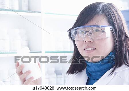 Stock Photo - Scientist holding bottle in lab. Fotosearch
