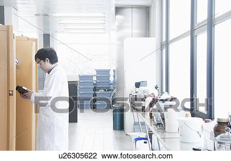 Scientist reading jar label in lab View Large Photo Image Stock Image - Scientist reading jar label in lab. Fotosearch