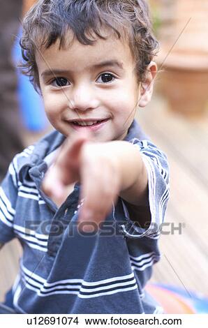 Smiling boy pointing forward View Large Photo Image Picture - Smiling boy pointing forward. Fotosearch