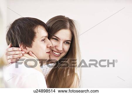 Smiling couple hugging indoors View Large Photo Image Picture - Smiling couple hugging indoors. Fotosearch